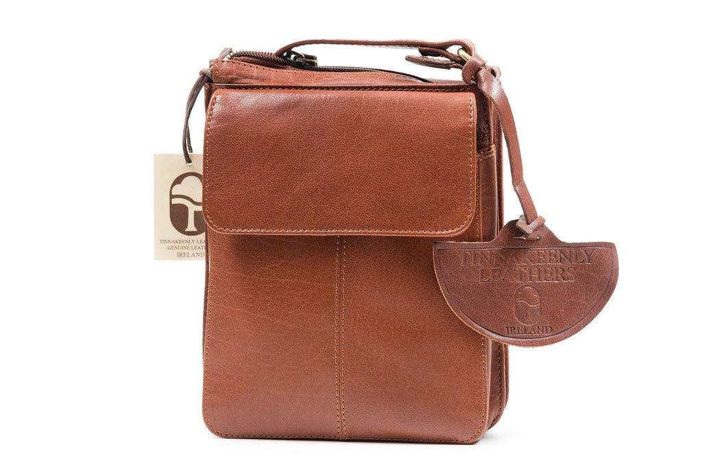 A leather shoulder bag made in vegetable tanned, drum dyed oily water Buffalo leather. Beautifully crafted, this bag is compact in size with a main zippered compartment and front pocket with flap to hold a wallet, cell phone and keys with a cross body adjustable strap.